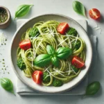 A plate of 5-Ingredient Pesto Pasta with grated Parmesan and halved cherry tomatoes.