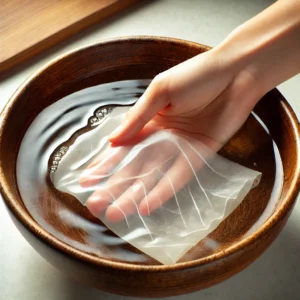 Rice paper wraps being soaked in warm water in a shallow bowl